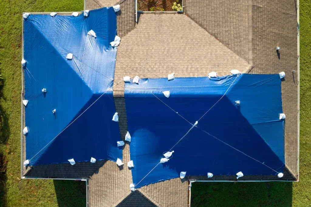Vue aérienne d’une toiture bâchée en bleu pour sécurisation d’urgence après sinistre